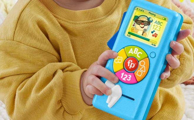 A Toddler Holding Fisher Price Laugh Learn Baby Learning Toy Puppys Music