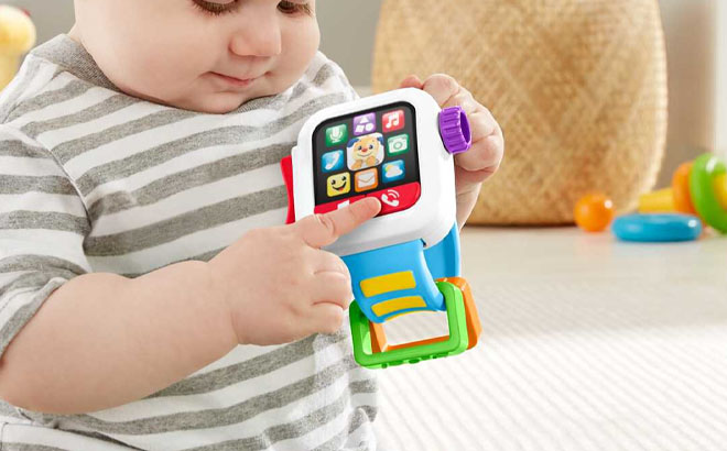 A Toddler PLaying Fisher Price Laugh Learn Time to Learn Smartwatch Electronic Musical Toy