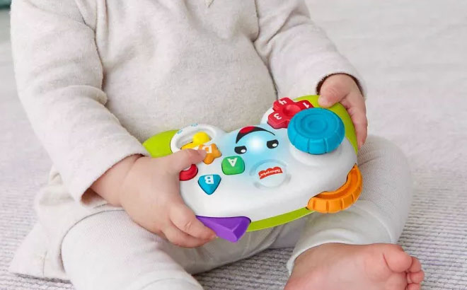A Toddler Playing Fisher Price Laugh and Learn Game and Learn Controller