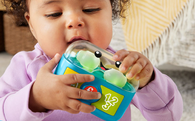 A Toddler Playing Fisher Price Learn Play Along Ear Buds