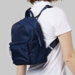 A Woman Wearing 32 Degrees Mini Backpack in Navy Color
