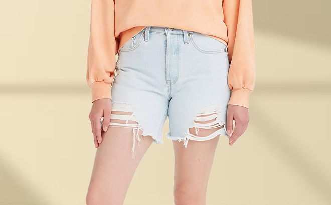 A Woman Wearing Levi's 501 Mid-Thigh Frayed Jean Shorts