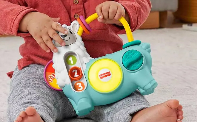 A child holding the Fisher Price Linkimals Learning Toy Llama