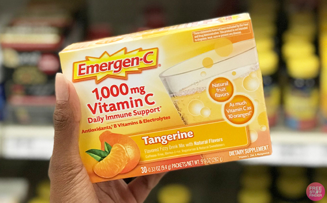 A person holding a box of Emergen C 1000mg Vitamin C Powder Tangerine Flavor