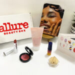 Allure Beauty Box next to Beauty Products and Plants on a Tabletop