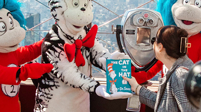 Dr Seuss Mascot Giving out a Cat in the Hat Book to a Lady