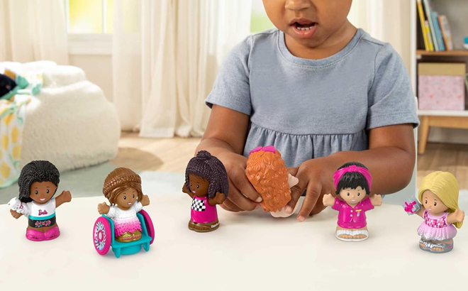 Girl Playing with the Fisher Price Little People Barbie Figures