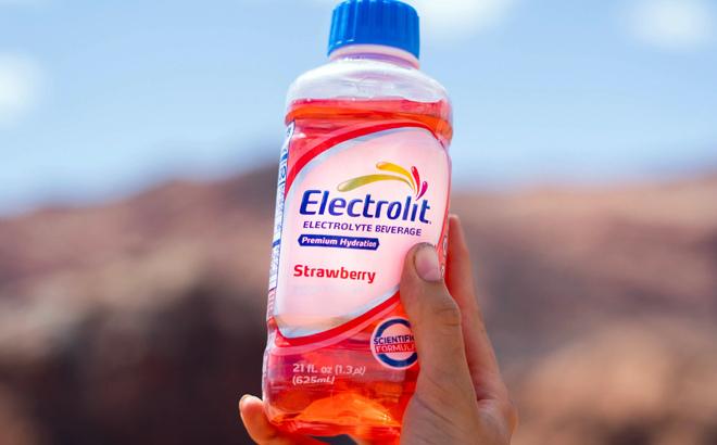 Hand holding one Electrolit Electrolyte Beverage Strawberry