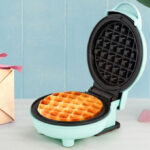 Holstein Housewares Mini Waffle Maker in Mint Color on a Table