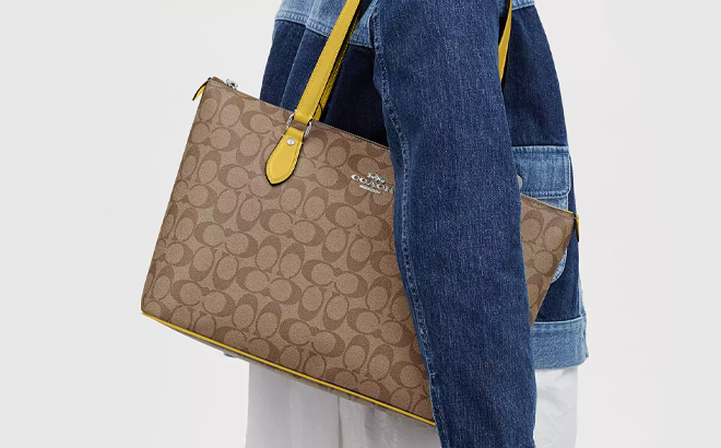 Lady carrying Coach Outlet Gallery Tote In Signature Canvas