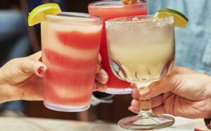 Three People Drinking Margaritas and Glass Clicking at Chuys