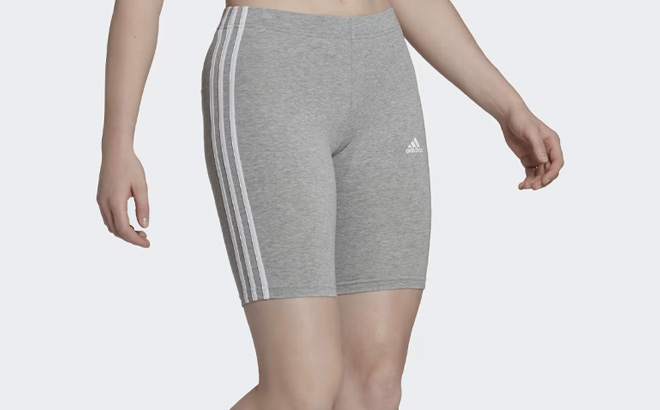 Woman is Wearing Adidas Essentials 3 Stripes Bike Shorts in Medium Grey Heather Color Woman is Wearing Adidas Essentials 3 Stripes Bike Shorts in Medium Grey Heather Color