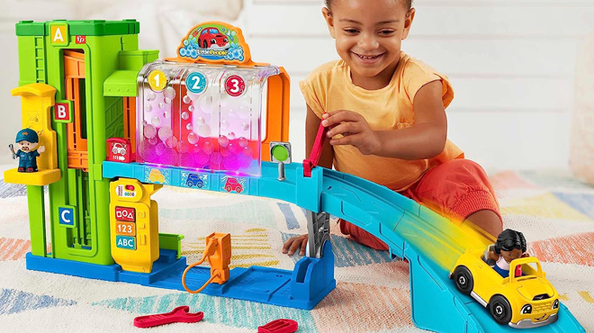 A Child Playing with Fisher Price Little People Light Up Learning Garage Playset