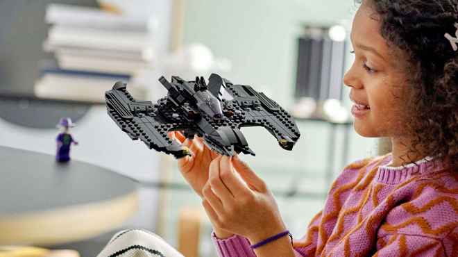 A Child Playing with LEGO DC Batwing Set