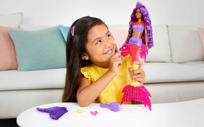 A Child Playing with a Barbie Mermaid Power Doll with Phoenix Pet and Accessories