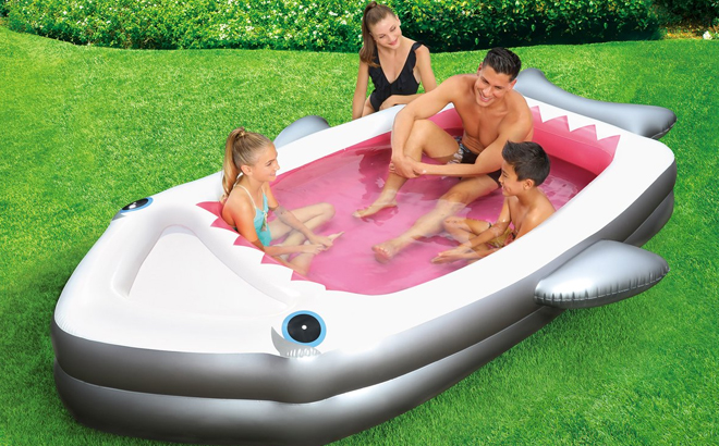 A Family Playing in the Summer Waves Inflatable Shark Pool