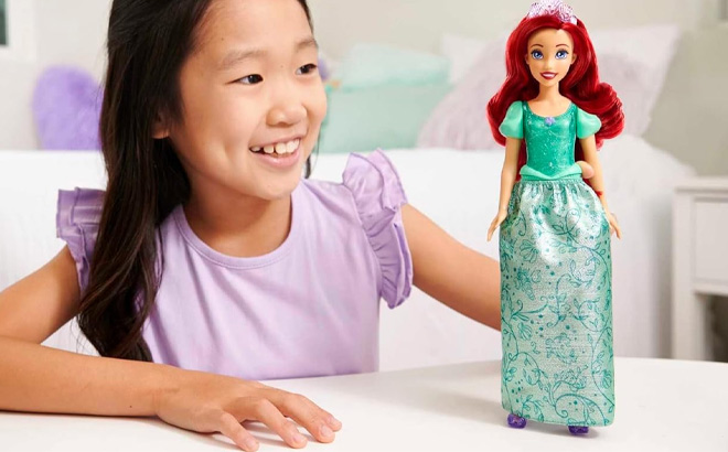 A Kid Holding Mattel Disney Princess Ariel Fashion Doll