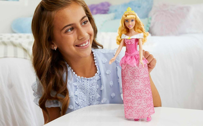 A Kid Holding Mattel Disney Princess Aurora Fashion Doll