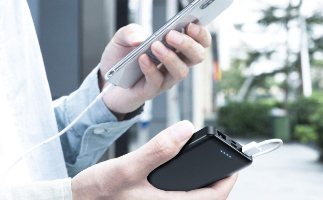 A Person Charging a Phone Using Aonimi Portable Charger Power Bank