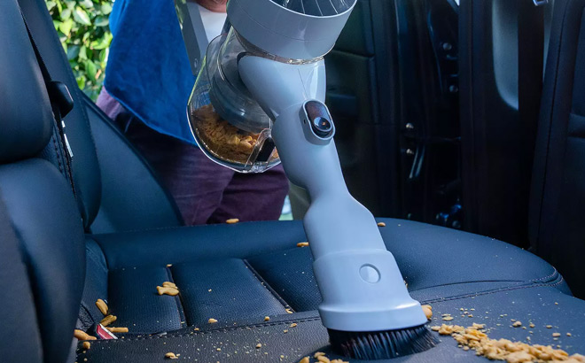 A Person Cleaning a Car Backseat using ineco C3 Cordless Stick Vacuum