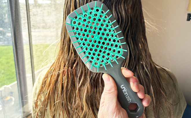A Person Holding UNbrush in Front of Wet Hair