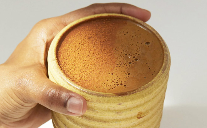 A Person Holding a Cup of MUDWTR Mushroom Based Coffee Alternative