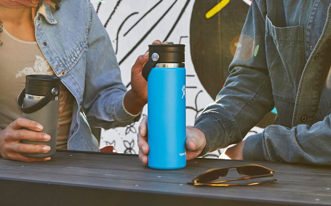 A Person Holding a Hydro Flask 20 Ounce Coffee Cup with Flex Sip Lid on a Table