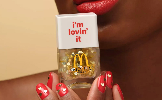 A Person Holding a Nails Inc x McDonald Nail Polish Im Lovin It Nail Topper