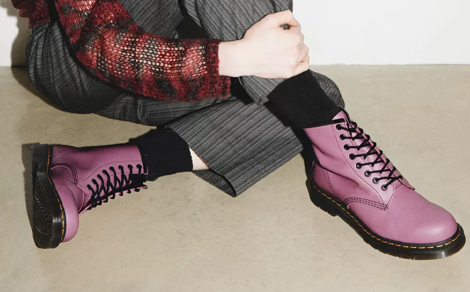 A Person Wearing Dr Martens 1460 Smooth Leather Lace Up Boots in Muted Purple Color
