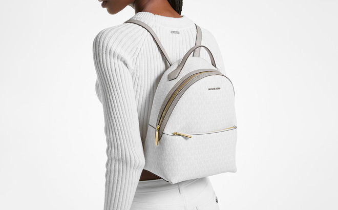 A Person Wearing Michael Kors Sheila Medium Logo Backpack in Optic White Color