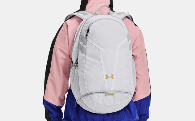 A Person Wearing Under Armour Hustle 5 0 Team Backpack in White Color