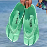 A Person is Holding Birkenstock Womens Honolulu EVA Sandals in Bold Jade Color
