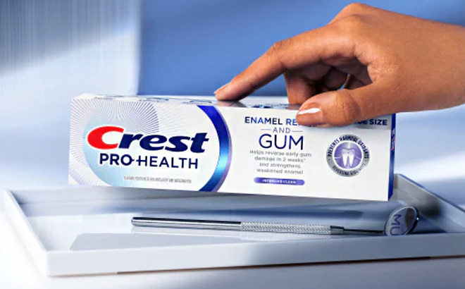 A Person is Holding Crest Toothpaste