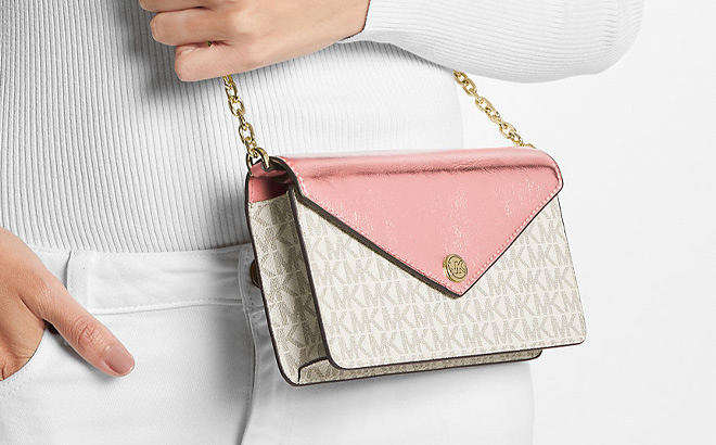 A Person is Holding Michael Kors Jet Set Travel Small Signature Logo Clutch Crossbody Bag in Primrose Multi Color