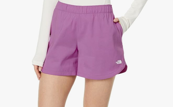 A Person is Wearing The North Face Class V Shorts in Purple Cactus Flower Color