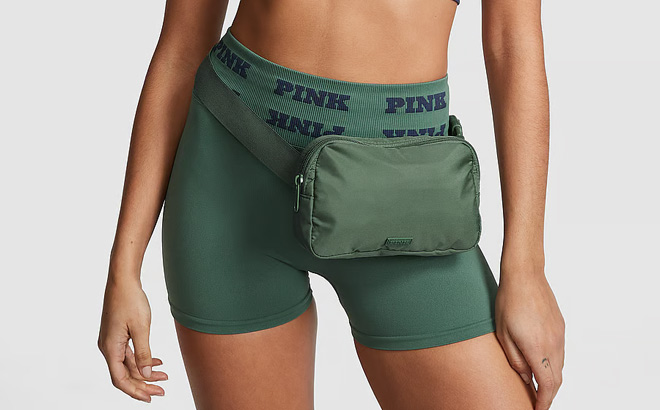 A Person is Wearing Victorias Secret Pink Belt Bag in Green Color