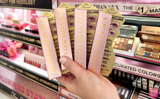 A Woman Holding 4 Packs of Too Faced Better Than Sex Mascara A Woman Holding 4 Packs of Too Faced Better Than Sex Mascara