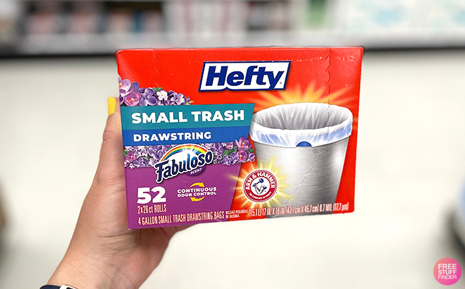 A Woman Holding a Box of Hefty 52 Count Small Trash Bags with Fabuloso Scent