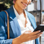 A Woman Looking at Her Mobile Phone and Smiling