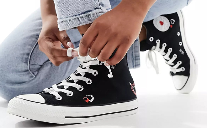 A Woman Tying Laces on the Converse Chuck Taylor All Star Sneakers