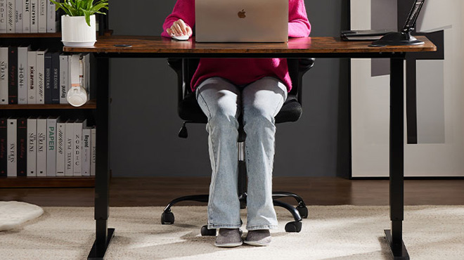A Woman Working on the Smug Electric Standing Desk in Rustic Brown