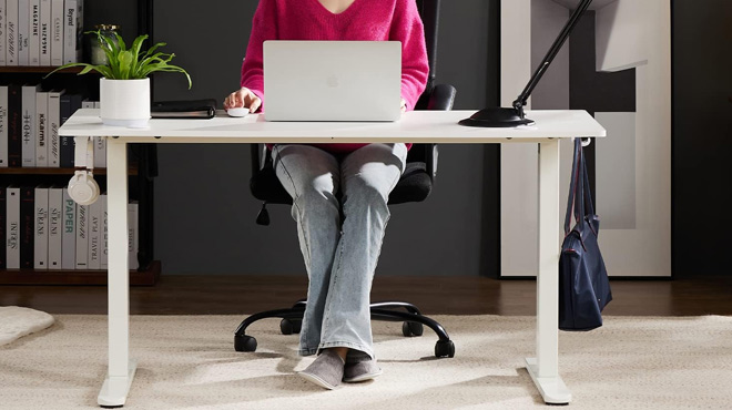 A Woman Working on the Smug Electric Standing Desk in White A Woman Working on the Smug Electric Standing Desk in White