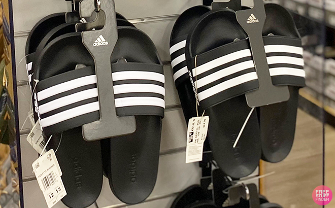 Adidas Adilette Shower Slides in Black and White on a Shelf at a Store