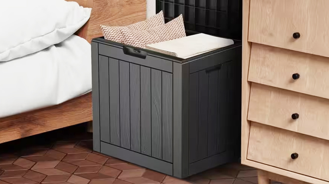 EasyUp 31 Gallon Black Resin Outdoor Storage Deck Box on a Bedroom Floor