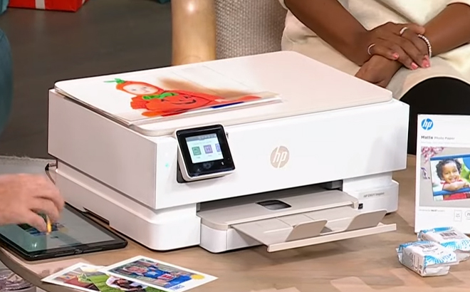 HP Envy Inspire All In One Printer with Ink and Photo Paper on a Table