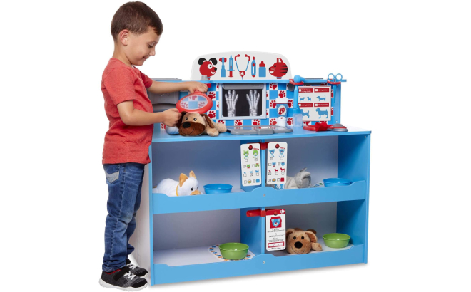 Little Boy Playing Pretend Vet with his Plush Animal Using Melissa Doug Animal Care Veterinarian and Groomer Wooden Activity Center