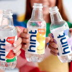 Three Persons Holding Hint Water Bottles