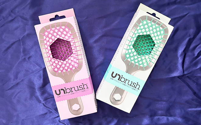Two Boxes of UNbrush on a Purple Cloth