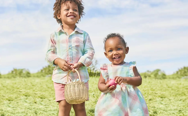Two Kids Wearing Carters Easter Apparel and Holding an Easter Basket with Easter Eggs