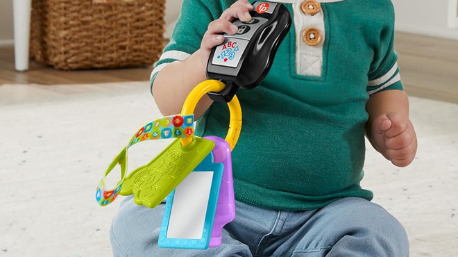 a Baby Playing with Fisher Price Laugh Learn Baby Travel Toy